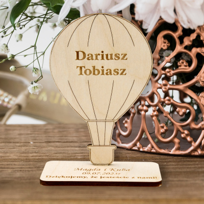 Personalizowana winietka drewniana podróżnicza w formie balonu stojąca na stole weselnym.