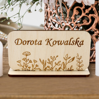 Prostokątne winietki boho z naturalnego drewna ze stabilną podstawką i precyzyjnym grawerem imienia oraz motywu kwiatowego na stole weselnym.