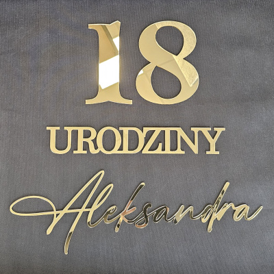 Personalizowany napis 18 urodziny z imieniem Aleksandra wykonany z lustrzanej złotej pleksi na szarym tle